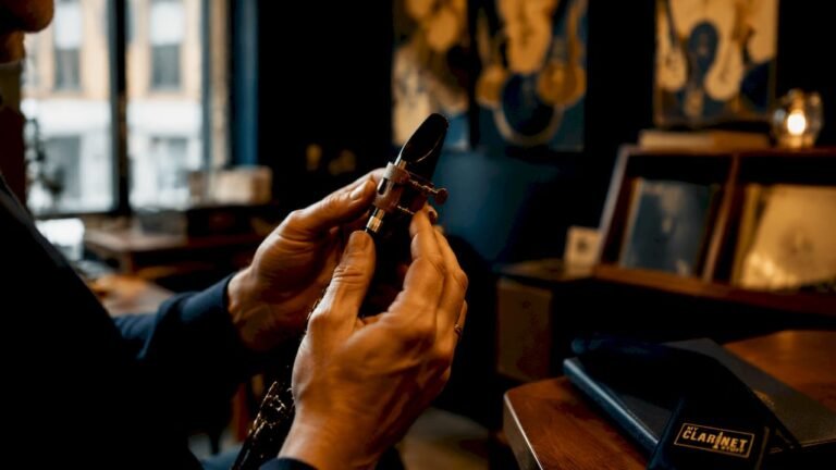 Hands adjusting clarinet ligature on mouthpiece