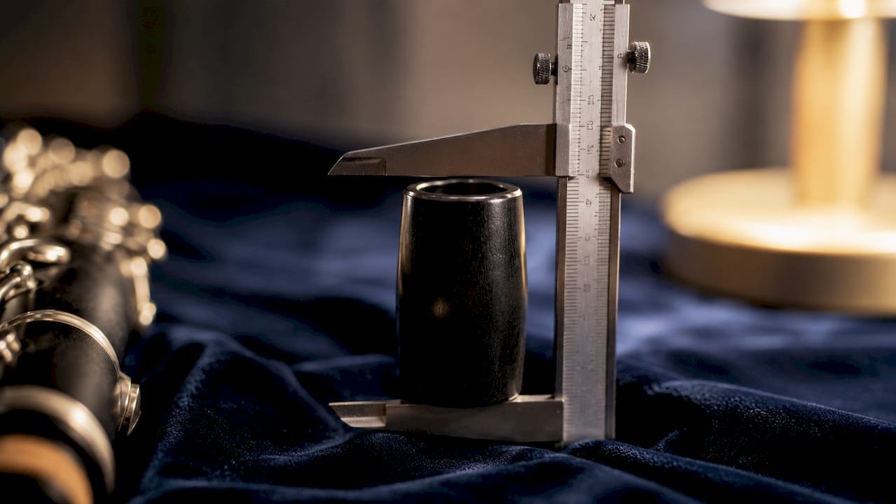 How Barrels Alter Resonance in Your Clarinet Clarinet barrel measured by caliper on grey surface