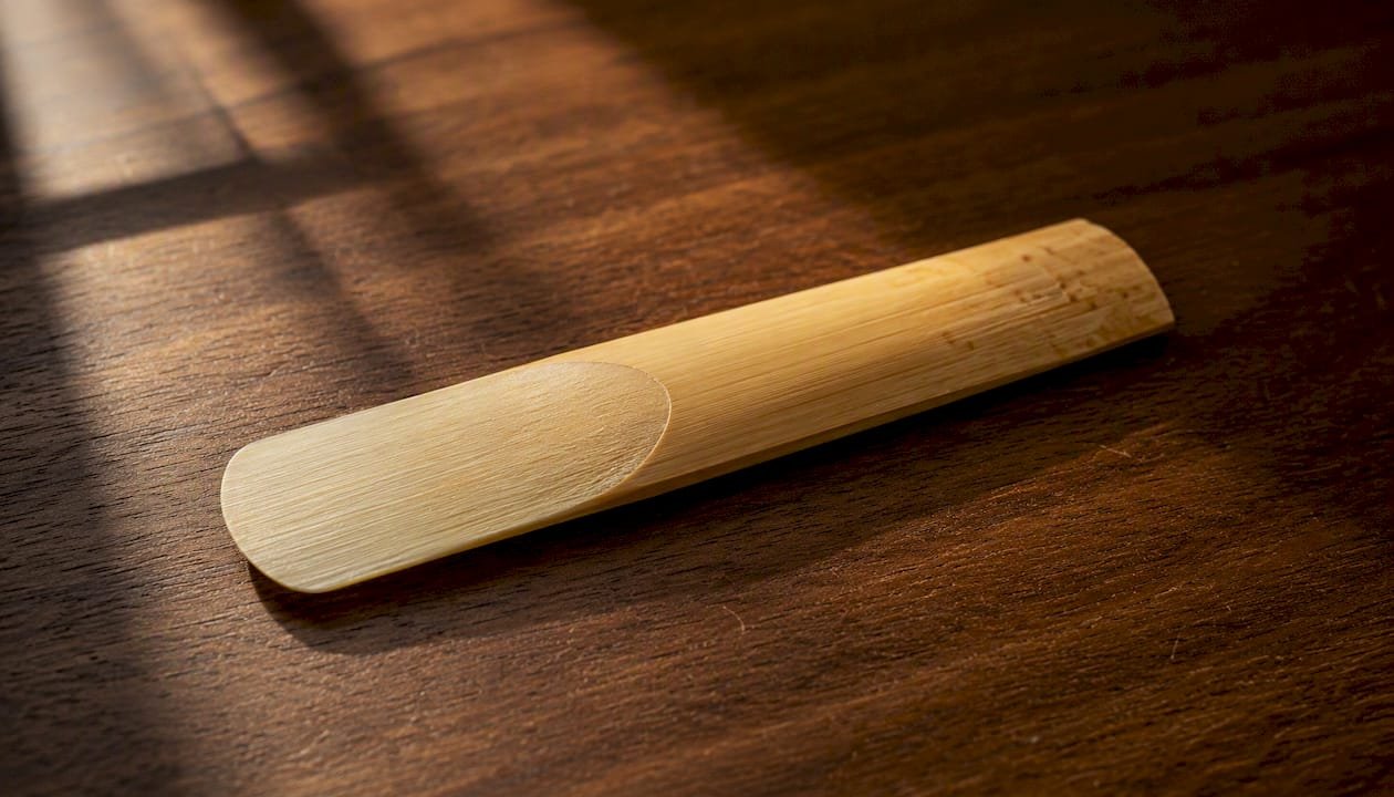 The Complete Guide to Reeds on a Clarinet Close-up clarinet reed parts visible on wooden surface